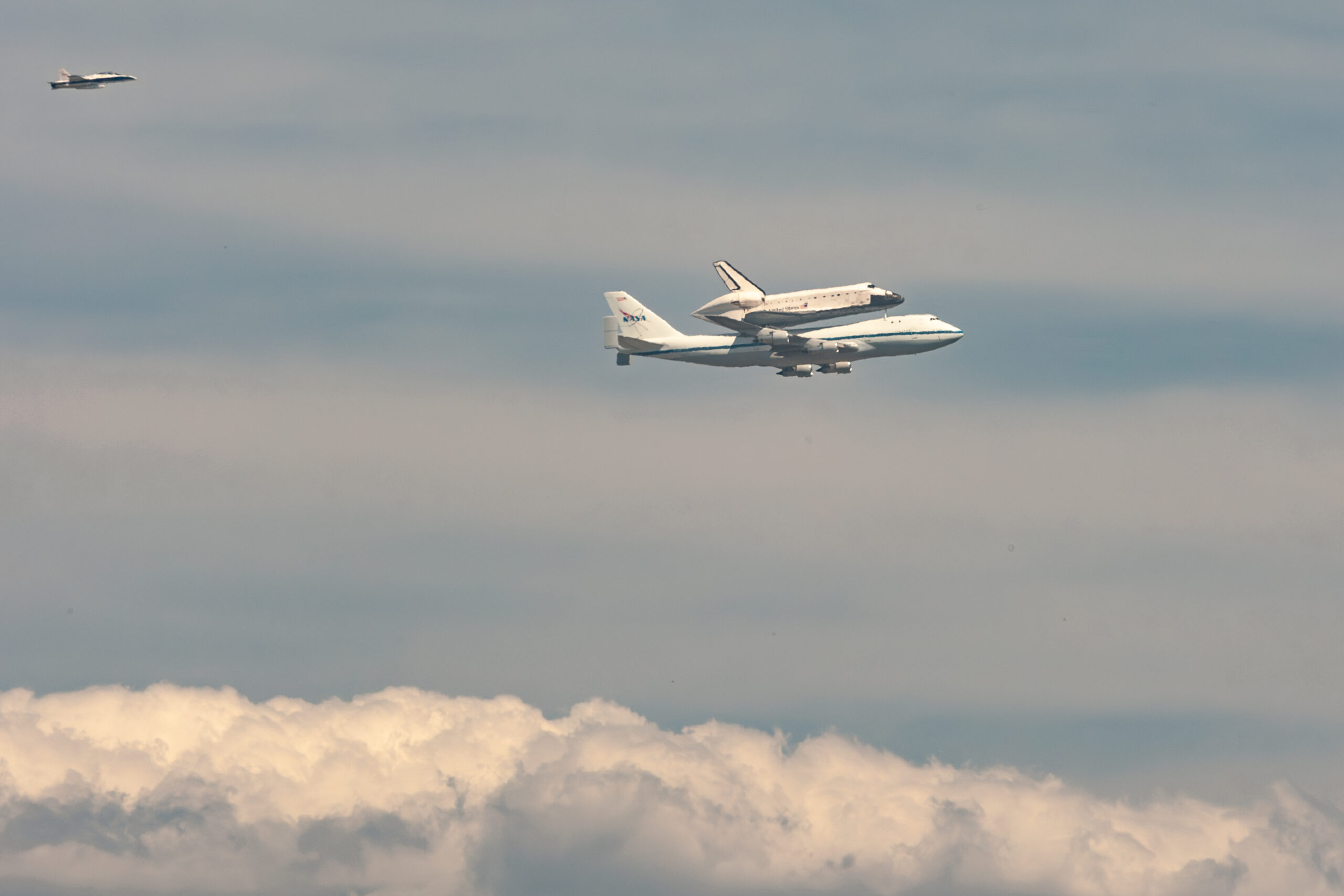 a photograph showing space shuttle Endeavour atop a 747 carrier jet as it passes by Cypress College on September 21, 2012 enroute to LAX and retirement at the California Science Center