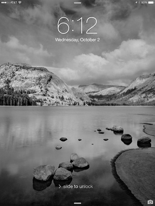 A photograph showing a lake in the foreground and mountains in the back as the lock screen image on an iPad