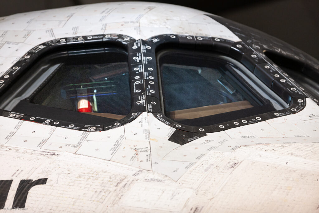 Photograph of space shuttle Endeavour showing part of the right side of the orbiter. Visible are two cockpit windows and some of the interior control switches.