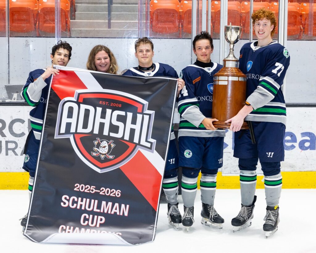 hockey players are presented a championship banner and trophy