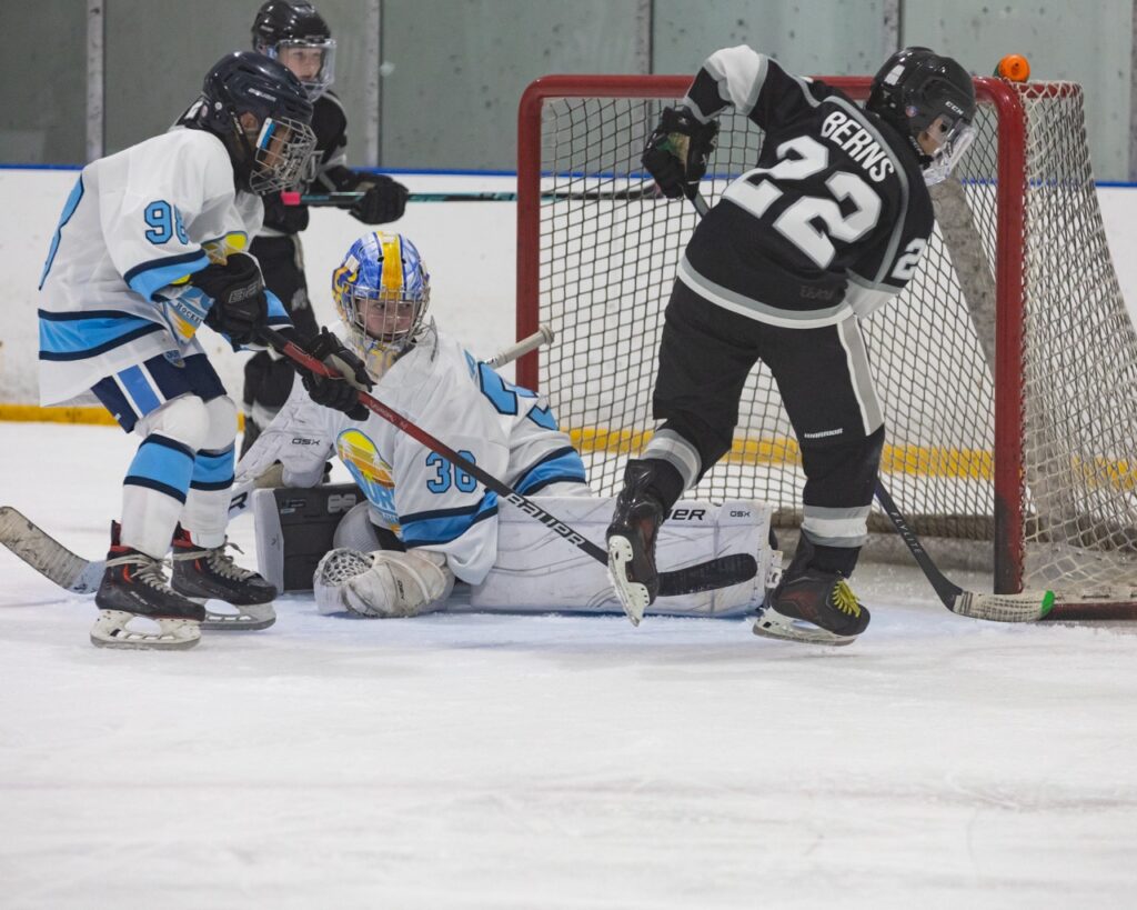an ice hockey goalie makes a toe save