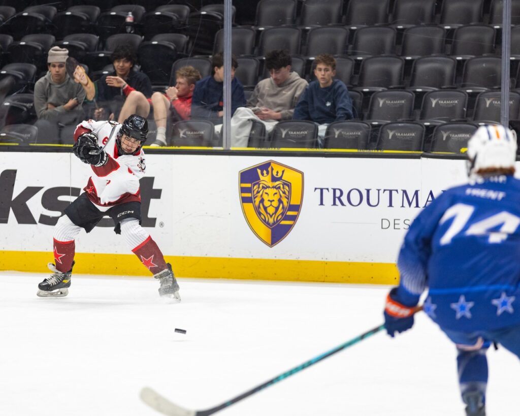 an ice hockey player shoots the puck on net