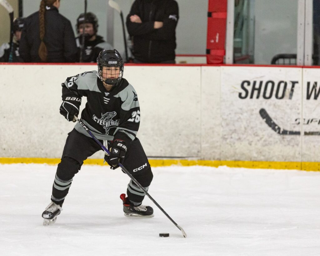 An ice hockey player passes the puck
