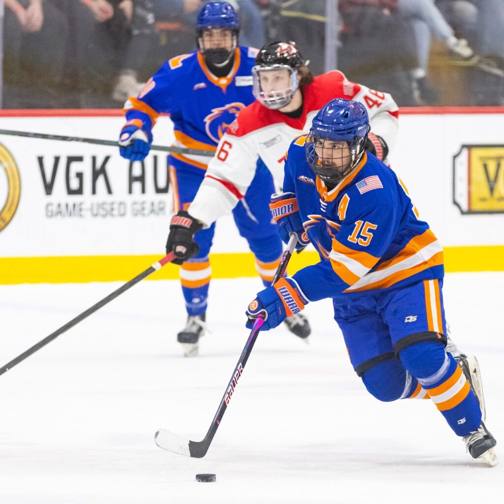 A hockey player skates with the puck